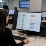 Υπάλληλος σε ψηφιακό κέντρο εξυπηρέτησης επεξεργάζεται ηλεκτρονικά αιτήματα για τη νέα πλατφόρμα e-ΕΦΚΑ.