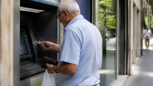 Συνταξιούχος χρησιμοποιεί ΑΤΜ για ανάληψη χρημάτων, για τις ημερομηνίες πληρωμής των συντάξεων Νοεμβρίου 2026.