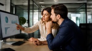Εργαζόμενος και υπεύθυνος εξετάζουν ψηφιακά δεδομένα σε χώρο εργασίας, για τη χρήση Τεχνητής Νοημοσύνης και την ανθρώπινη εποπτεία.